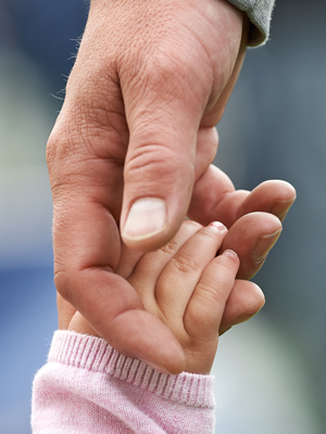 child and parent holding hands